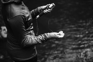 Black and white photo of a woman preparing to cast a Daggerfish hand line fishing reel