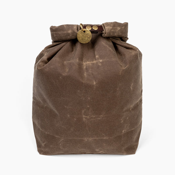 Closed large forest brown waxed canvas roll top stuff sack with leather closure and brass tag 