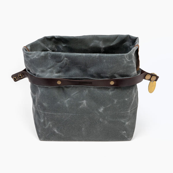 Open medium slate gray waxed canvas roll top stuff sack with leather closure and brass tag 