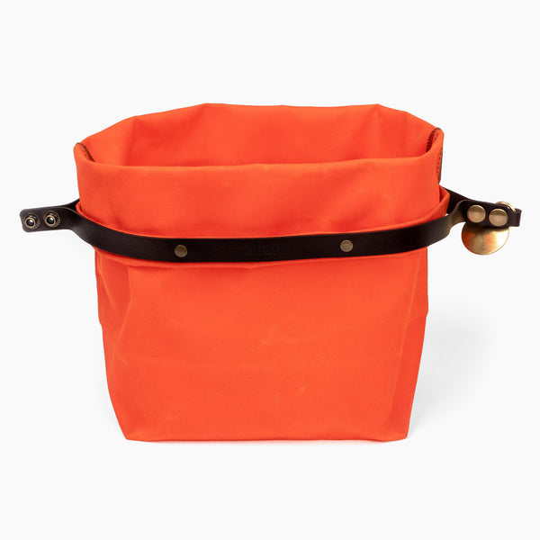 Open medium hunter orange waxed canvas roll top stuff sack with leather closure and brass tag 