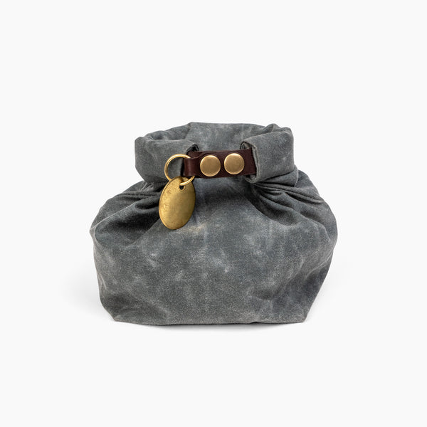 Closed Small Slate Gray waxed canvas roll top stuff sack with leather closure and brass tag 